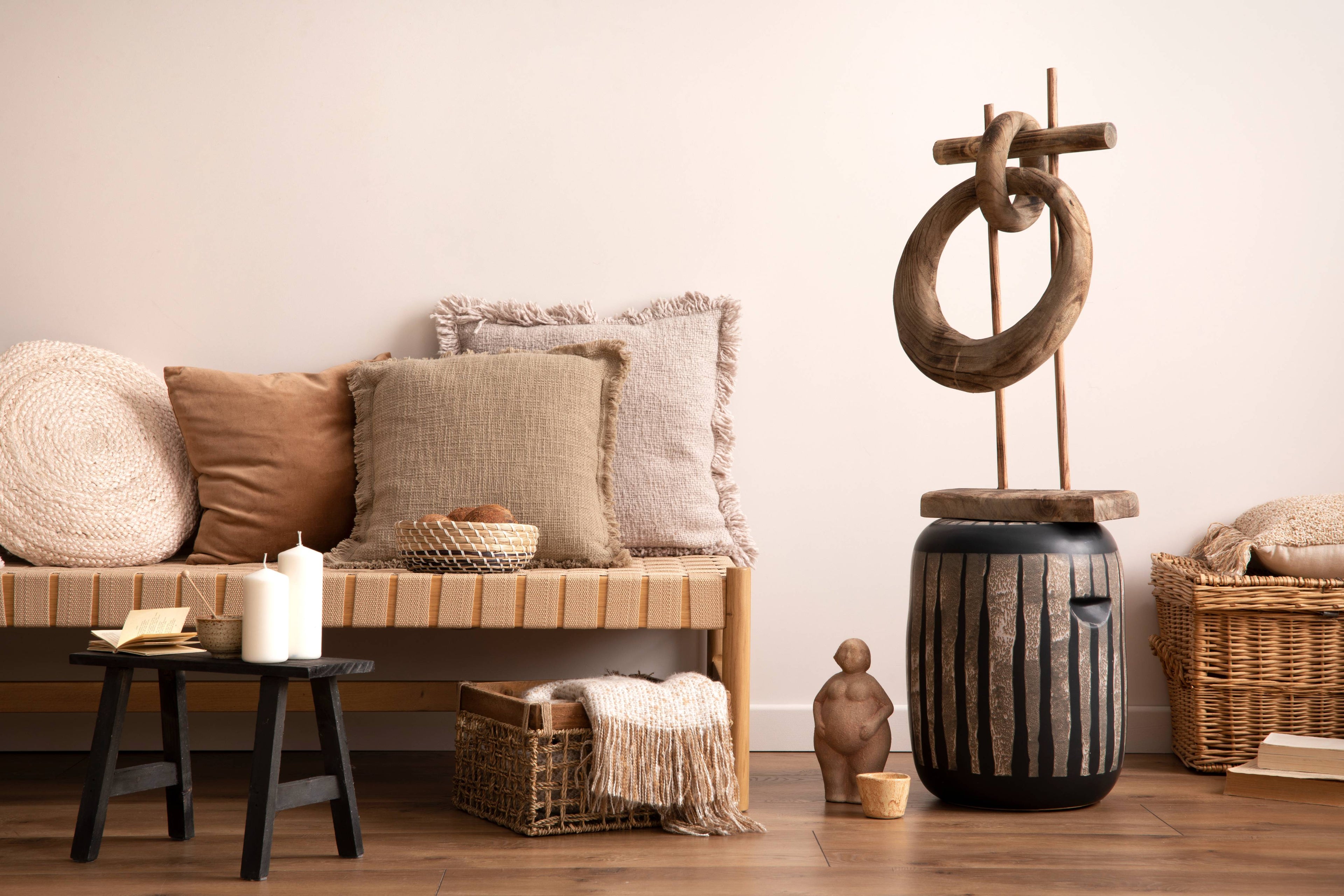 Nest living room with wooden bench, decorative items, and a candle.